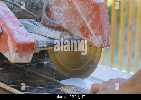 Builder in cutting tiles with big electro saw on the construction cutting ceramic tile Stock Photo