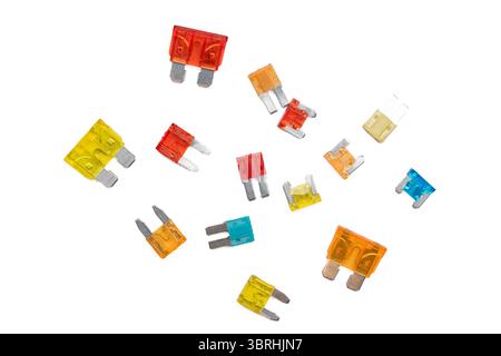 A scattered assortment of colorful blade fuses of different sizes isolated on a white background. Commonly used in vehicle fuse boxes. Stock Photo