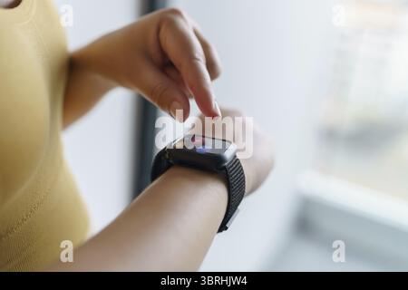 Woman workout with health app on smart watch Close-up hands Stock Photo