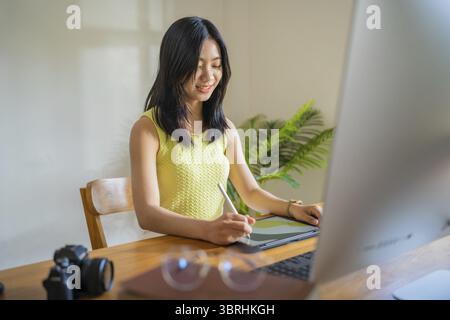 Graphic designer working on digital tablet and computer. Designer Asian Woman artist drawing on graphic tablet Artist Creative Designer sketch graphic Stock Photo