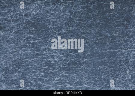 Midnight blue hues dominate textured wall with network of white thread-like lines creating web pattern resembling sky filled with lightening bolts. Stock Photo