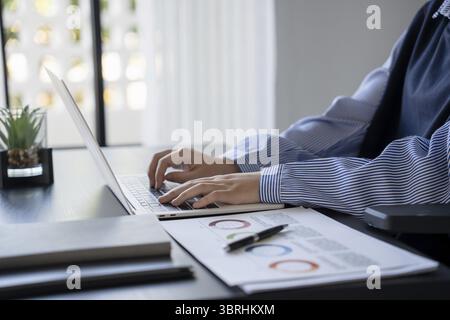 Asian businesswoman using laptop doing documents Stock Photo