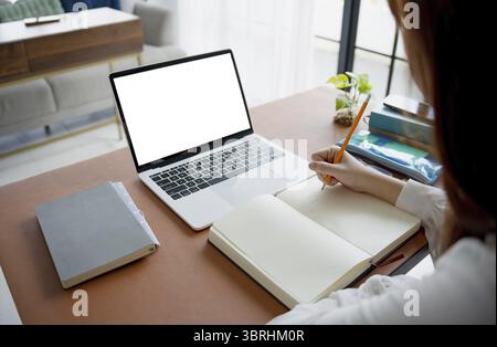 Students sitting at desk using laptop blank screen computer working in office mockup image blank screen computer white background Stock Photo