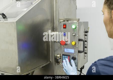 Woman working in industry, adjusting equipament Stock Photo