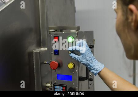 Woman working in industry, adjusting equipament Stock Photo