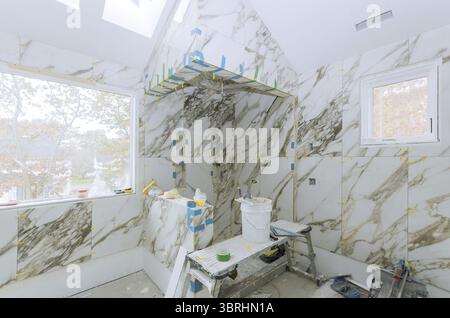 Construction work installing ceramic tile on reconstruction of bathroom during or renovation Stock Photo