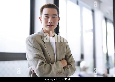Smiling young Asian businessman in modern office. handsome asian man happy and friendly while working success job Stock Photo