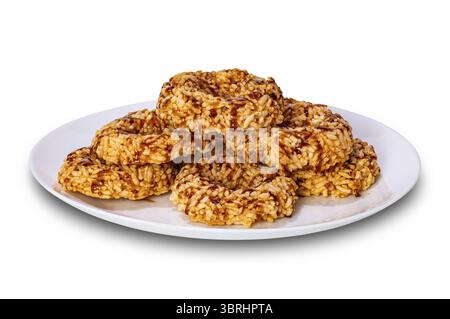 Crispy homemade rice crackers with cane sugar syrup in white ceramic plate isolated on white background with clipping path Stock Photo