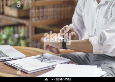 Business man Looking at smart watch In Office online connect Gadget technology Stock Photo