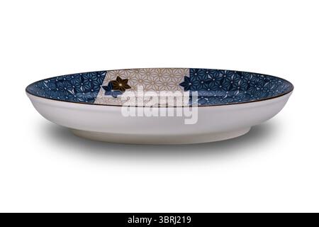 Side view of empty blue and brown star pattern dark edge ceramic plate isolated on white background with clipping path Stock Photo