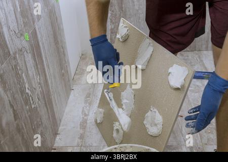 Spreading wet mortar before applying tiles on bathroom floor tile Stock Photo