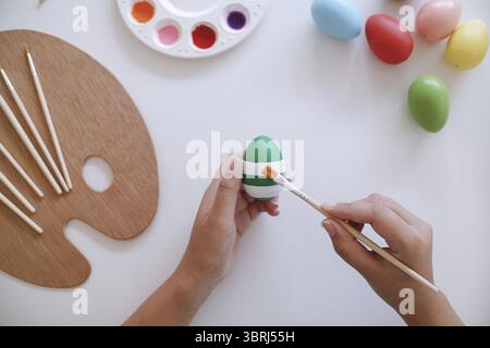 Woman painting Easter eggs at home. family preparing for Easter. Hands of a girl with a easter egg Stock Photo