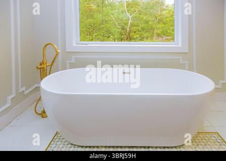 Large furnished bathroom in luxury home with bathtub white installing custom in master bathroom Stock Photo