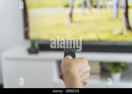 Elderly woman Watching smart TV and using remote controller Hand holding television audio remote control Middle age Asian woman movie Television serie Stock Photo