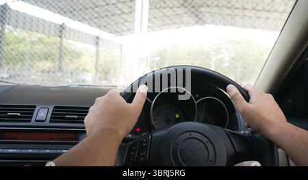 Man driving with both hands on steering wheel selective focus. safety driving concept Stock Photo