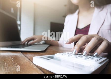 Business woman analyzing investment charts with calculator laptop. Accounting and technology in office.Business people using laptop at office Analyze Stock Photo