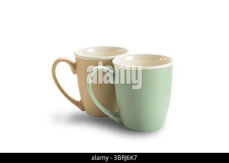 View of two empty ceramic coffee mugs brown and green isolated on white background with clipping path Stock Photo