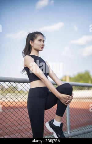 Active healthy asian woman exercising by running, jogging runner sports stadium during the morning healthcare and well being concept Stock Photo