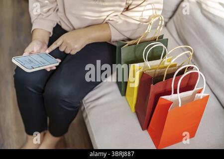 Woman hands holding cell telephone using smartphone sale shopping bags. consumerism lifestyle concept in the shopping mall with shopping bag Stock Photo