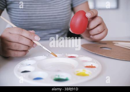 Woman painting Easter eggs at home. family preparing for Easter. Hands of a girl with a easter egg Stock Photo