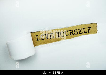 Love Yourself message written on craft paper with torn paper background Stock Photo