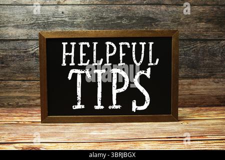 Helpful Tips text with blackboard on wooden background Stock Photo