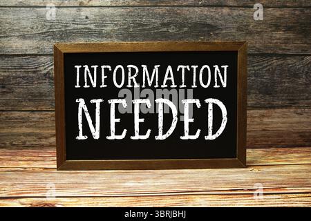 Information Needed text on blackboard standing on wooden background Stock Photo
