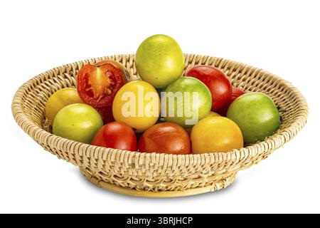 Side view closeup of freshly harvested multi colored cherry tomatoes in bamboo basket isolated on white background with clipping path Stock Photo