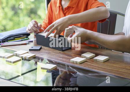 Asian father and son playing wood blocks game Carefree kid playing wood blocks game building constructor from blocks with father at home Stock Photo