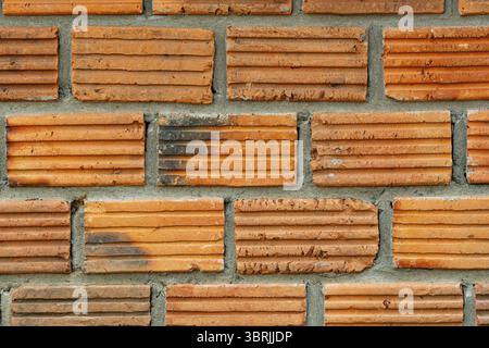 Closeup view of old grunge red brick wall background. The old wall of grooved bricks with cement Stock Photo