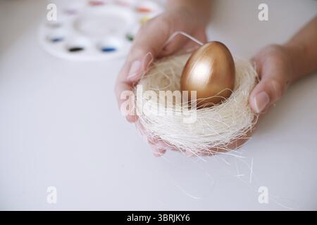 Woman painting Easter eggs at home. family preparing for Easter. Hands of a girl with a easter egg Stock Photo