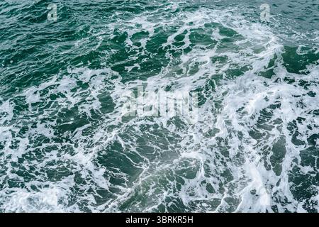 Abstract aerial view of swirling sea foam on deep green water Stock Photo