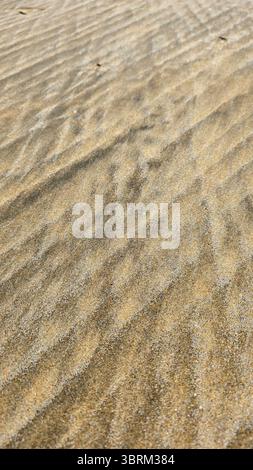 A natural beautiful cross lines pattern in soft colors in ocean or sea sand. Beautiful sand textures and backgrounds. Vertical format. Stock Photo