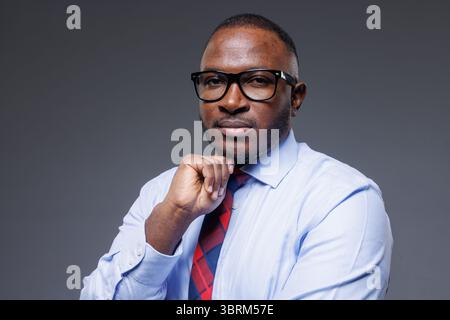 Thoughtful african businessman in formal suit and glasses, symbol of leadership, confidence, and business success Stock Photo