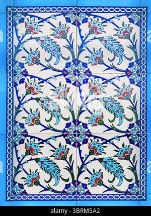 30 April 2025, Ildir, Turkiye: Close up of a glazed ceramic tile panel with a repeating floral motif, showcasing the beauty of turkish artistry Stock Photo