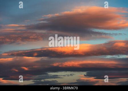 Stunning sunset sky showcasing vibrant clouds in shades of orange and pink, creating a peaceful and dreamy atmosphere at dusk Stock Photo