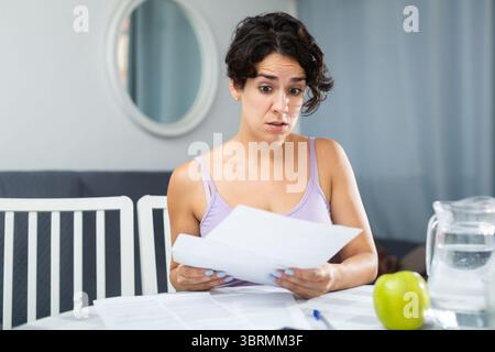 Portrait of troubled woman looking at papers Stock Photo