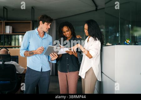 A diverse, talented team collaborates effectively in a bright office space during a business meeting Stock Photo