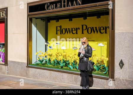 New York, New York - February 21, 2022: A woman standing in front of the Cole Haan store at Rockefeller Centre in New York City Stock Photo