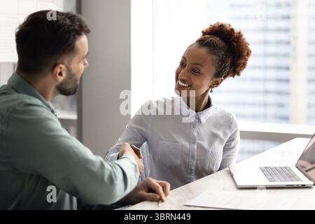 African businesswoman greeting company client met in office Stock Photo