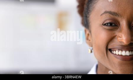 Close up cropped view half face of smiling African businesswoman Stock Photo