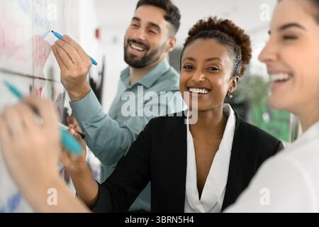 Happy teammates working on plan or project in office Stock Photo