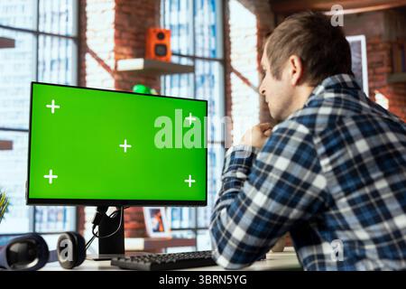 Employee completing spreadsheets on chroma key computer, entering numerical data into cells, calculating totals. Man analyzing figures on isolated screen PC monitor, using spreadsheet software Stock Photo