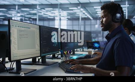 Computer scientist putting headphones on in server room, working to ensure minimal downtime. Engineer using audio device to hear podcasts in data center, monitoring performance, camera A Stock Photo