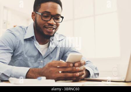 Young black businessman using mobile phone Stock Photo
