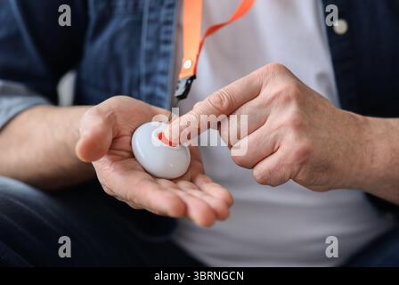 Hand pushing panic button on emergency equipment for elderly people Stock Photo
