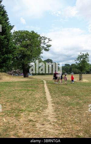 A dirt path through Prospect park, Reading, UK. It is the middle of a heatwave and the grass has turned brown. Stock Photo