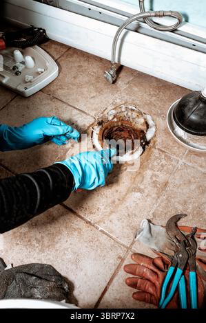Close-up view of a Professional plumber replacing old wax ring seal before toilet installation, with copy space. Stock Photo