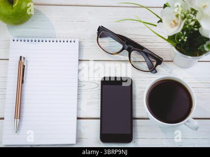 Flat design wooden desk workspace is showing notebook, pen, apple, smartphone, coffee mug Stock Photo
