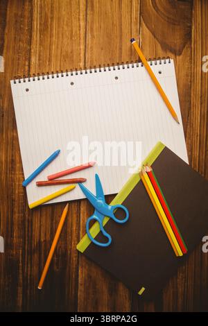 Flat design scene is showing spiral notebook is lying on wooden tabletop with crayons and pencils Stock Photo